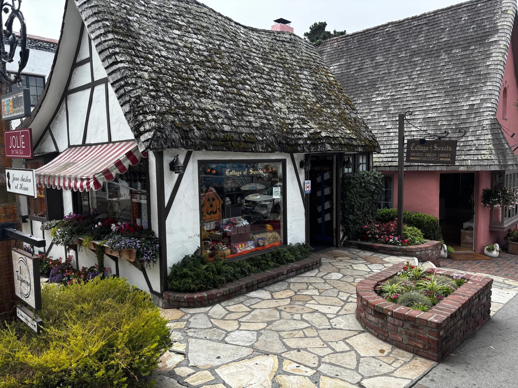 The Cottage of Sweets, a storybook-style shop with a steep roof and flower boxes