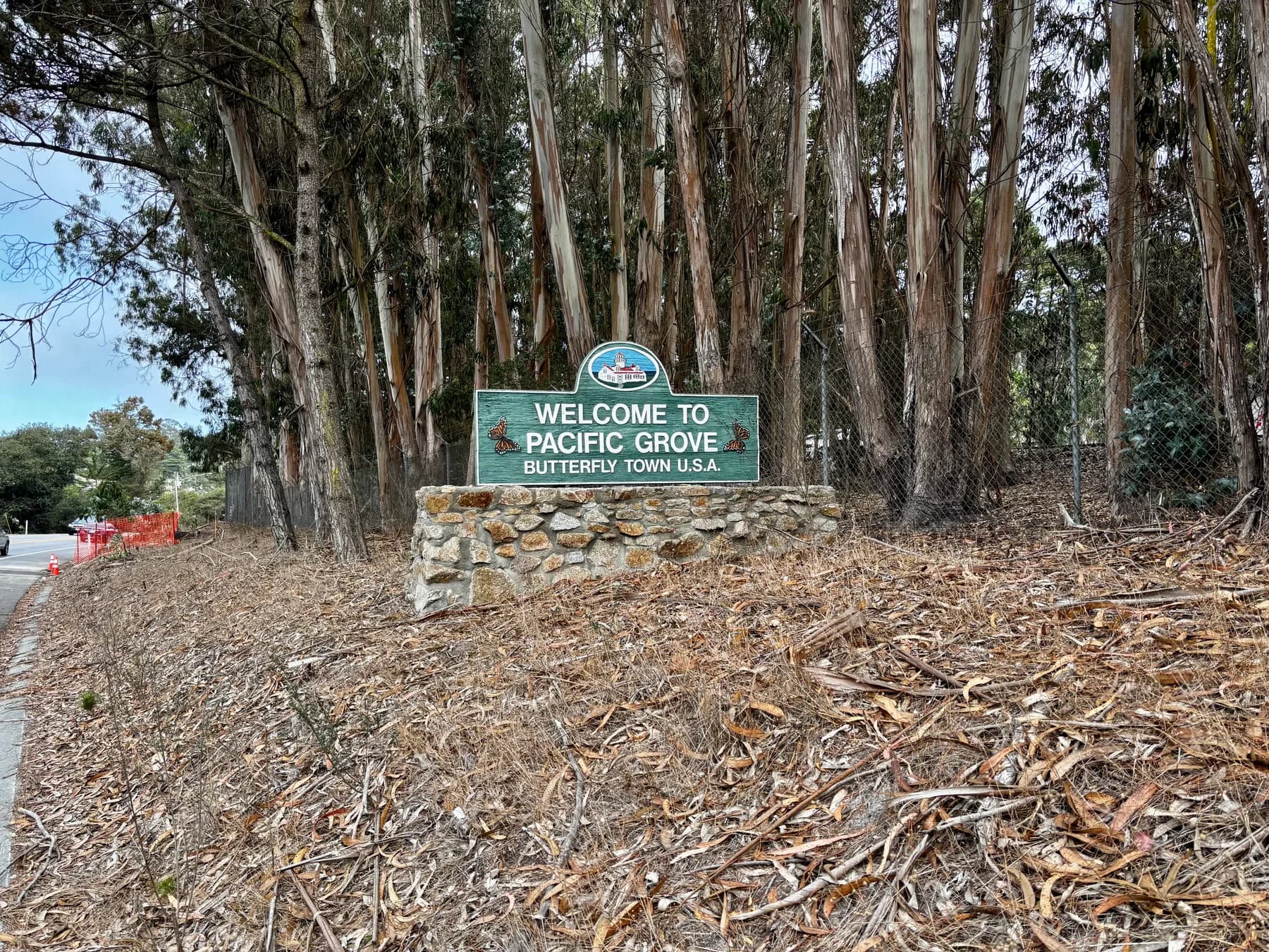 Welcome to Pacific Grove sign among trees, reading Butterfly Town USA